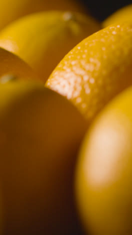 Vertical-Video-Studio-Shot-Of-Oranges-Revolving-Against-Black-Background