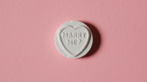 Heart-Candy-With-Marry-Me-Message-On-Pink-Background