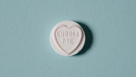 Heart-Candy-With-Cuddle-Me-Message-On-Blue-Background