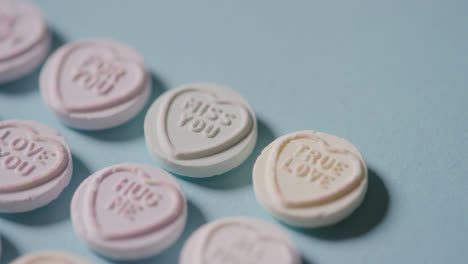 Full-Frame-Shot-Of-Heart-Candy-With-Romantic-Messages-Of-Love-On-Blue-Background