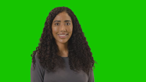 Portrait-Of-Woman-Against-Green-Screen-Smiling-At-Camera