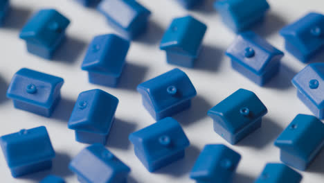 Hauskaufkonzept-Mit-Einer-Gruppe-Blauer-Plastikmodelle-Von-Häusern,-Die-Sich-Auf-Weißem-Hintergrund-Drehen