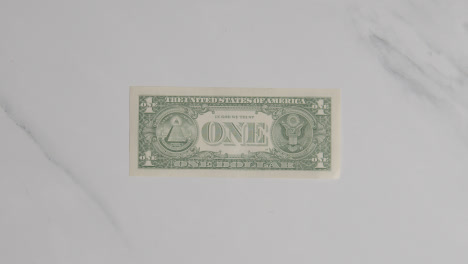 Overhead-Currency-Shot-Of-Hand-Grabbing-US-1-Dollar-Bill-On-Marble-Surface