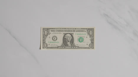 Overhead-Currency-Shot-Of-Hand-Grabbing-US-1-Dollar-Bill-On-Marble-Surface-2