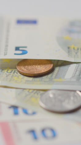 Vertical-Video-Close-Up-Currency-Shot-Of-Euro-Notes-And-Coins-Counted-Out-On-Marble-Surface