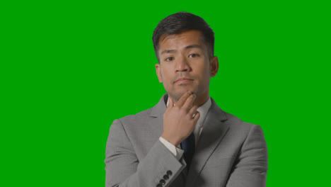 Portrait-Of-Serious-Businessman-In-Suit-Thinking-Against-Green-Screen-Having-Idea