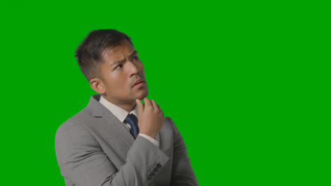 Portrait-Of-Serious-Businessman-In-Suit-Thinking-Against-Green-Screen-