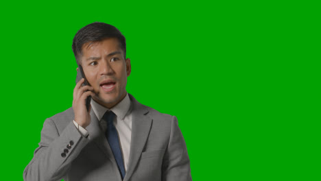 Studio-Shot-Of-Angry-Businessman-In-Suit-Talking-On-Mobile-Phone-Against-Green-Screen-1