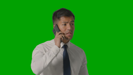 Studio-Shot-Of-Angry-Businessman-In-Shirt-And-Tie-Talking-On-Mobile-Phone-Against-Green-Screen-2