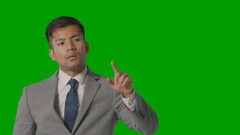 Studio-Shot-Of-Businessman-In-Suit-Pretending-To-Use-AI-Or-VR-Screen-Against-Green-Screen-