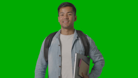 Portrait-Of-Smiling-Male-University-Or-College-Student-With-Laptop-Against-Green-Screen-1