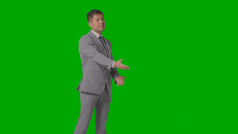 Three-Quarter-Length-Shot-Of-Angry-Businessman-In-Suit-Against-Green-Screen-Talking-Off-Camera