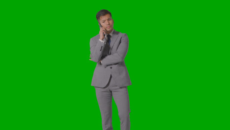 Three-Quarter-Length-Studio-Shot-Of-Businessman-In-Suit-Taking-Mobile-Phone-Call-Against-Green-Screen-