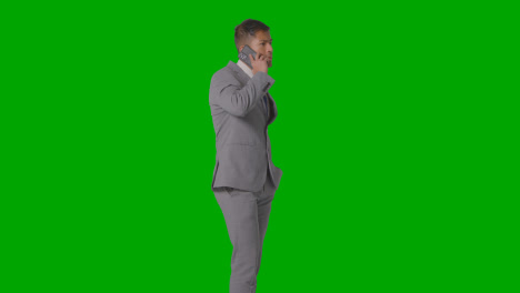 Three-Quarter-Length-Studio-Shot-Of-Unhappy-Businessman-In-Suit-Talking-On-Mobile-Phone-Against-Green-Screen-3