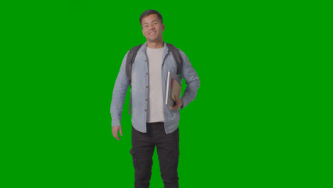 Three-Quarter-Length-Portrait-Of-Smiling-Male-University-Or-College-Student-With-Laptop-Against-Green-Screen-1