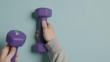 Overhead-Fitness-Studio-Shot-Of-Male-Hand-Putting-Down-Exercise-Dumbbell-Weights-1