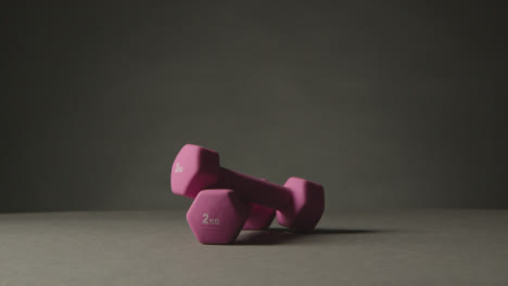 Fitness-Studio-Shot-Of-Exercise-Dumbbell-Weights-Against-Grey-Background