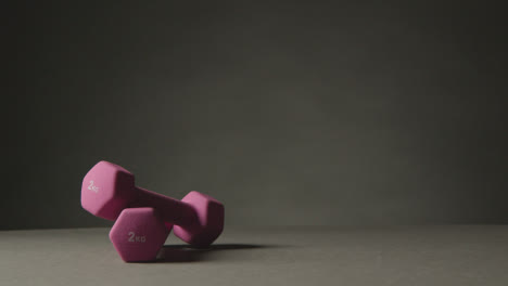 Fitness-Studio-Shot-Of-Exercise-Dumbbell-Weights-Against-Grey-Background-1