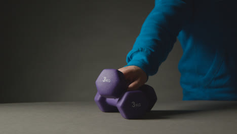 Fitness-Studio-Aufnahme-Mit-Der-Hand,-Die-Übungshantelgewichte-Vor-Grauem-Hintergrund-Aufhebt-8