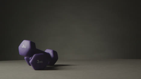 Fitness-Studio-Shot-With-Hand-Picking-Up-Exercise-Dumbbell-Weights-Against-Grey-Background-9