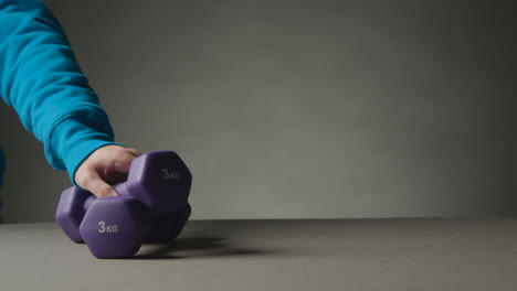 Fitness-Studio-Aufnahme-Mit-Der-Hand,-Die-Übungshantelgewichte-Vor-Grauem-Hintergrund-Aufhebt-9