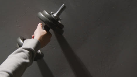 Overhead-Studio-Fitness-Shot-Of-Hand-Picking-Up-Gym-Weight-On-Grey-Background-2