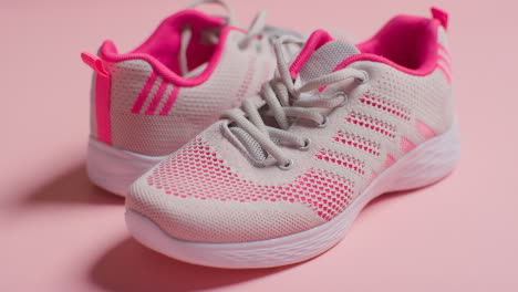 Fitness-Studio-Shot-With-Pair-Of-Training-Shoes-On-Pink-Background-Pulled-Into-Focus