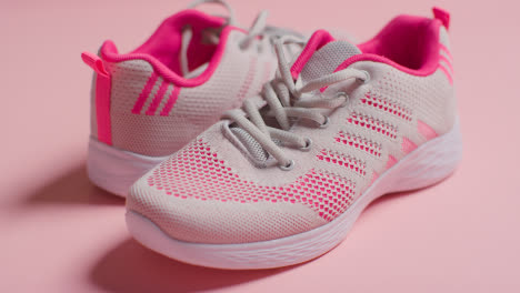 Foto-De-Estudio-De-Fitness-Con-Un-Par-De-Zapatos-De-Entrenamiento-Sobre-Fondo-Rosa-Enfocados