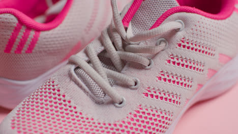 Foto-De-Estudio-De-Fitness-Con-Un-Par-De-Zapatillas-De-Entrenamiento-Sobre-Fondo-Rosa-Enfocadas