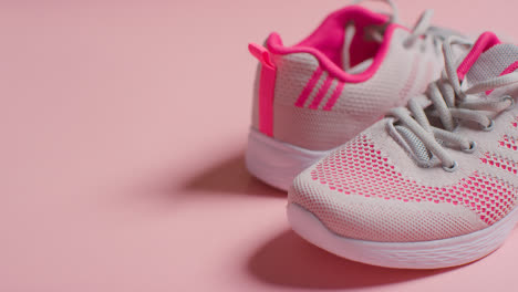 Fitness-Studio-Shot-With-Pair-Of-Training-Shoes-On-Pink-Background-Pulled-Into-Focus-1