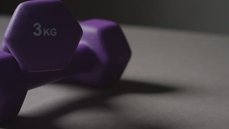 Close-Up-Studio-Fitness-Shot-Of-Purple-Gym-Hand-Weights-On-Grey-Background