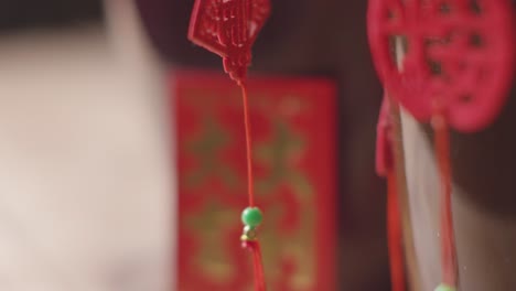 Nahaufnahme-Von-Dekorationen,-Die-Das-Chinesische-Neujahr-Feiern-Und-Zu-Hause-An-Einer-Pflanze-Mit-Einer-Karte-Hängen