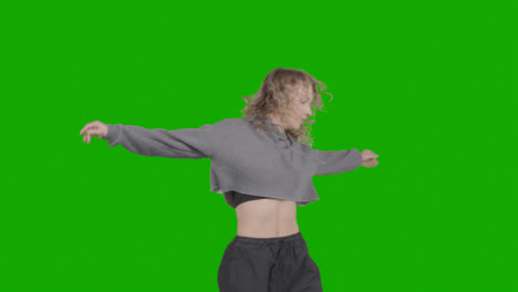 Studio-Shot-Of-Young-Woman-Having-Fun-Dancing-Against-Green-Screen-12