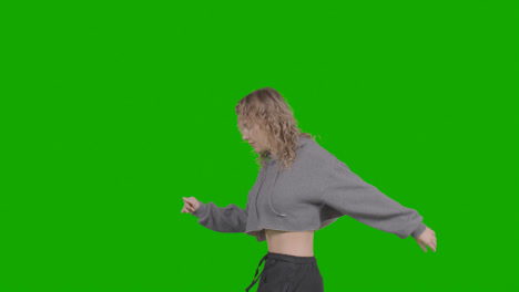 Studio-Shot-Of-Young-Woman-Having-Fun-Dancing-Against-Green-Screen-13