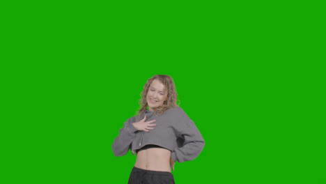 Studio-Shot-Of-Young-Woman-Having-Fun-Dancing-Against-Green-Screen-14