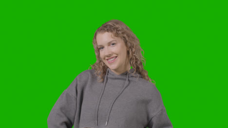 Studio-Portrait-Of-Smiling-Young-Woman-Against-Green-Screen-1