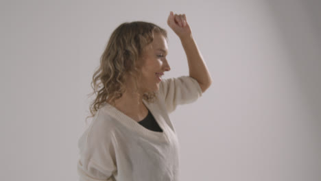 Studio-Shot-Of-Young-Woman-Having-Fun-Dancing-Against-White-Background