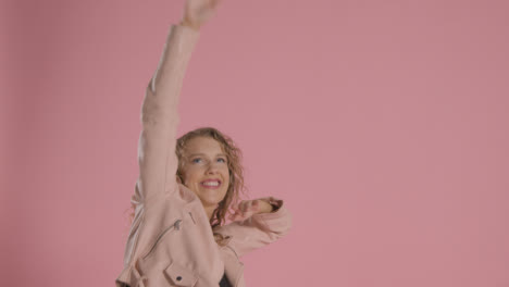 Studio-Shot-Of-Young-Woman-Having-Fun-Dancing-Against-Pink-Background-4