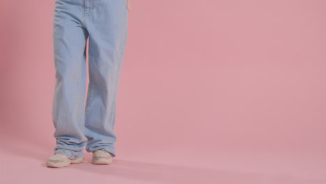 Close-Up-On-Legs-And-Feet-Of-Woman-Having-Fun-Dancing-Against-Pink-Studio-Background