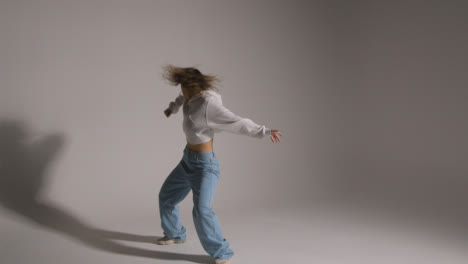 Full-Length-Studio-Shot-Of-Young-Woman-Having-Fun-Dancing-Against-Grey-Background-2