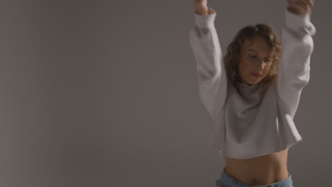 Studio-Shot-Of-Young-Woman-Having-Fun-Dancing-Against-Grey-Background-5