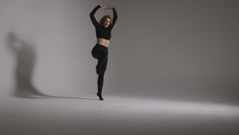 Full-Length-Studio-Shot-Of-Young-Woman-Doing-Dance-Practise-Against-Grey-Background