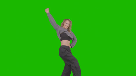 Studio-Shot-Of-Young-Woman-Having-Fun-Dancing-Against-Green-Screen-27