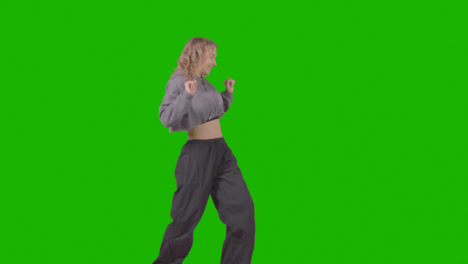 Full-Length-Studio-Shot-Of-Young-Woman-Having-Fun-Dancing-Against-Green-Screen-4