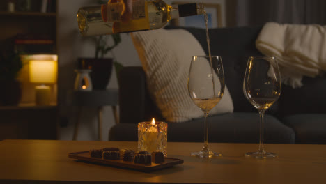 Mann-Plant-Einen-Romantischen-Abend-Zu-Hause-In-Der-Lounge-Mit-Wein-Und-Schokolade