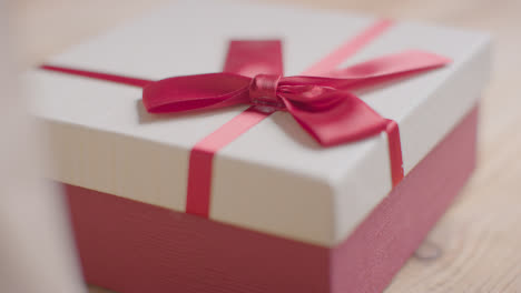 Nahaufnahme-Romantischer-Valentinsgrüße-In-Geschenkverpackung-Auf-Dem-Tisch,-Die-In-Den-Fokus-Rücken