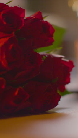 Vertikales-Video-Nahaufnahme-Von-Strauß-Roter-Rosen-Zum-Valentinstag-Auf-Dem-Tisch