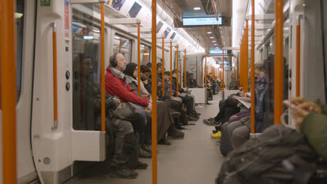 Toma-Interior-De-Pasajeros-Que-Viajan-En-Un-Vagón-De-Tren-Del-Reino-Unido-Temprano-En-La-Mañana