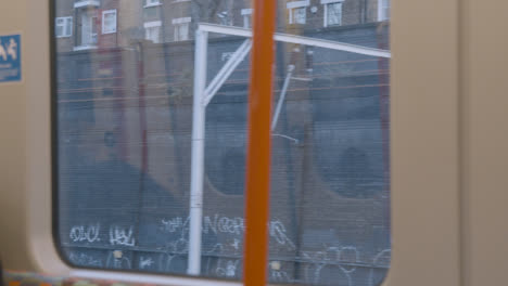 Blick-Auf-Die-Stadt-Vom-S-Bahn-Fenster-Mit-Graffiti-Und-Stromleitungen