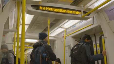 Pantalla-De-Información-Dentro-Del-Vagón-De-Tren-De-Tubo-En-La-Línea-Metropolitana-De-Londres,-Reino-Unido-Con-Los-Viajeros